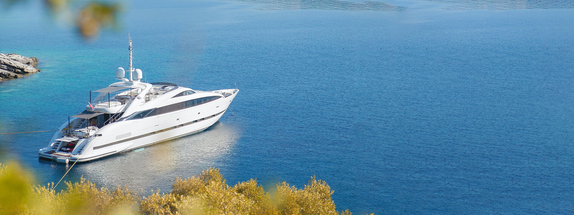 A mega yacht anchors in a bay | Exclusive Megayacht Insurance via Hanseatic Yacht Brokers
